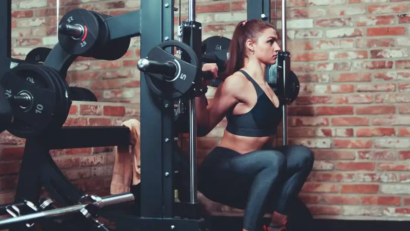 Athletic woman exercising squatting at Half rack