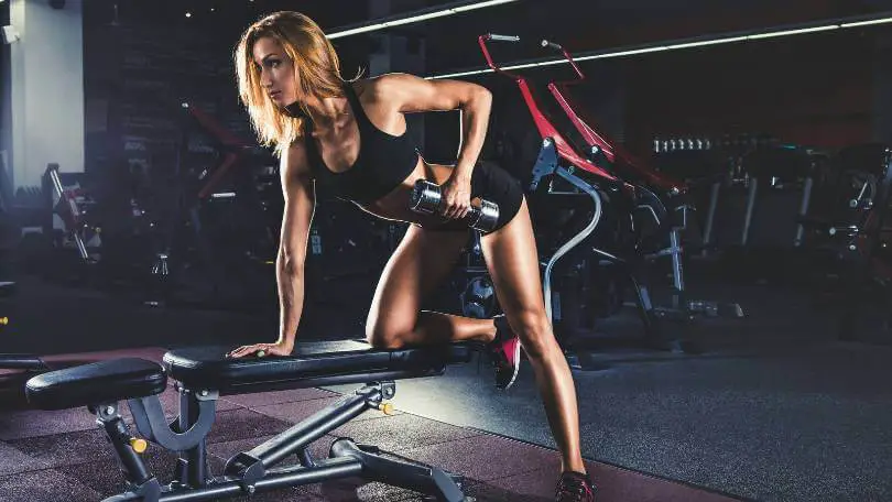 Girl pumping up muscles with small dumbbells