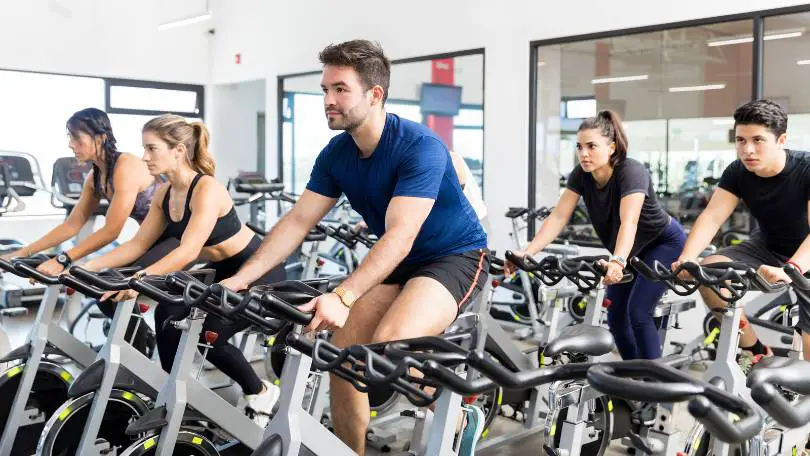 Sporty People Riding Exercise Bikes