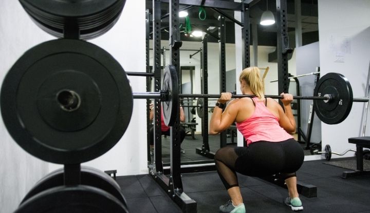 women doing squat using squat rack and power rack