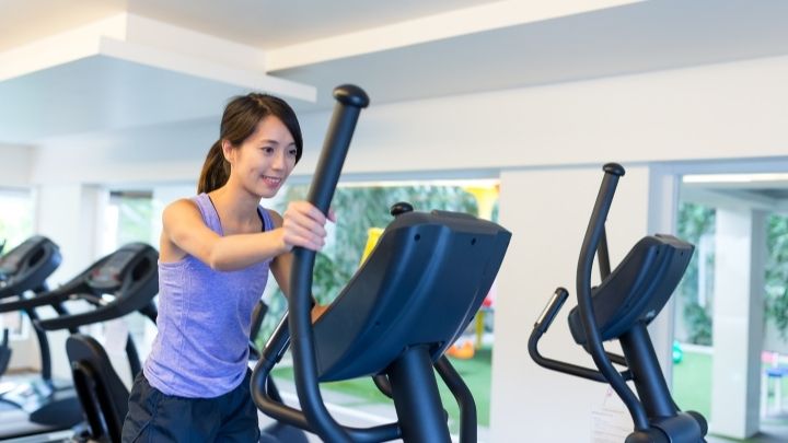 woman works out on affordable elliptical machine for rigorous cardio workouts